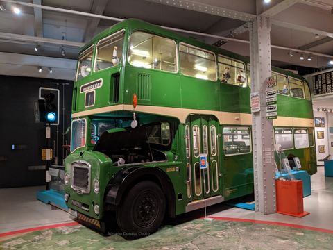 Em destaque na imagem, um ônibus verde antigo.