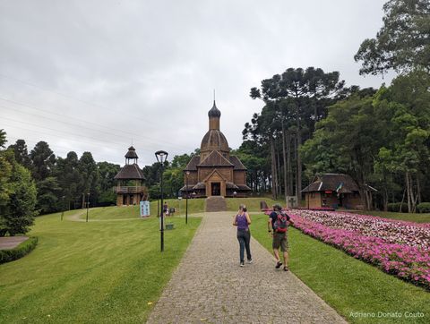 Um caminho de pedra, ladeado por gramado, leva a um grupo de construções de madeira. São três no total, sendo uma espécie de coreto, uma capela e uma casa.