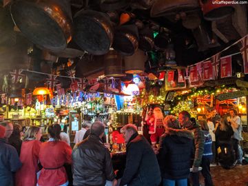 Interior do The Churchill Arms. De louça e bandeiras aos mais diversos objetos de época, a ornamentação no teto é de um charme à parte.