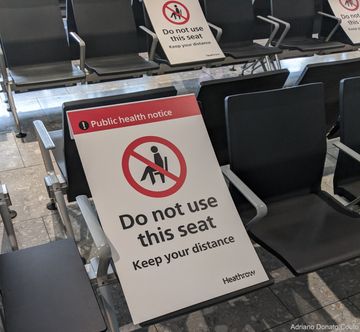 Placa solicitando para que se evite alguns assentos, mantendo distanciamento social entre grupos. Terminal 5 do Aeroporto London Heathrow.