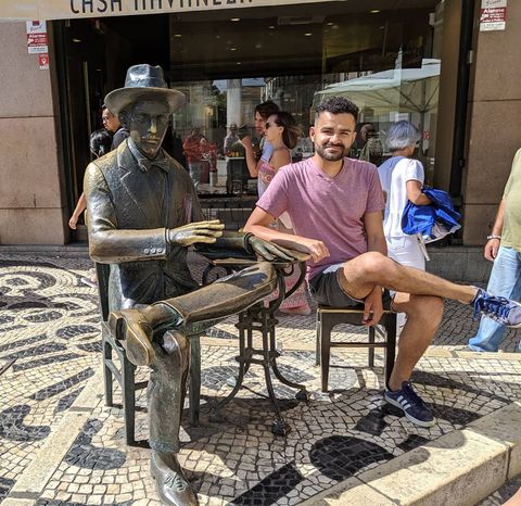 Aqui, estou sentado ao lado de uma estátua de Fenando Pessoa, em frente ao Café A brasileira, em Lisboa.