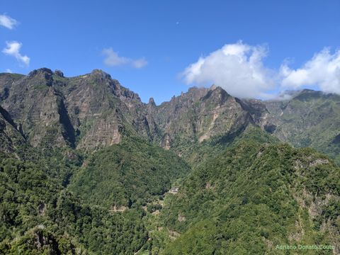 "Cadeira montanhosa, toda coberta de verde. Acima, um cén azul com poucas nuvens."
