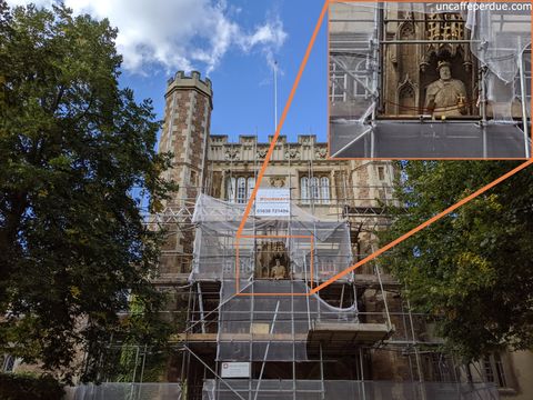 Henrique VIII na fachada da Trinity College. Consegue ver na parte em zoom o rei com uma das mãos vazias? Na ocasião, a perna da cadeira havia sido retirada por conta da restauração da fachada.