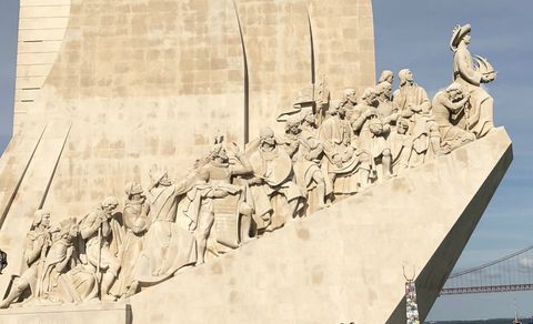 Em um monumento em formato de paralelepípedo, uma rampa lateral, que sobe em direção ao rio (à direita), possui uma série de esculturas, sendo algumas de navegadores e outras figuras importantes do período das grandes navegações portuguesas. A foto mostra o lado contrário do mesmo monumento da imagem anterior, mas com close na região das esculturas, que também estão deste lado.