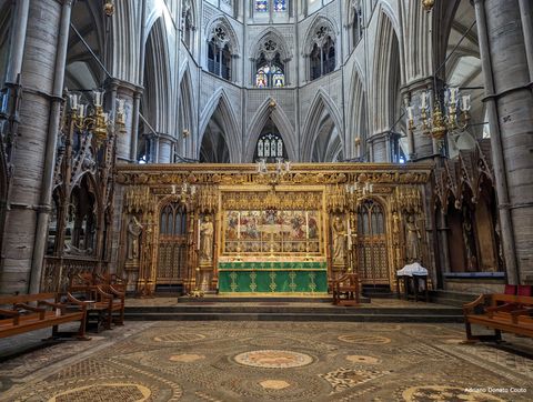 Dentro de uma igreja em estilo gótico, vemos um espaço com piso em mosaico. Ao fundo, um painel dourado, com algumas esculturas e pinturas. Logo em frente, uma mesa coberta de tecido verde. É o altar desta abadia.