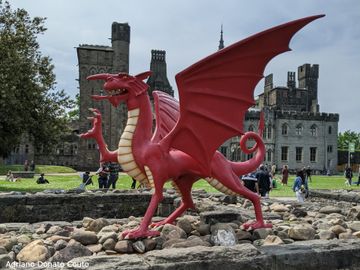 Ao fundo, prédios antigos. Em primeiro fundo, uma escultura de um dragão vermelho, um dos símbolos do País de Gales e figura presente em sua bandeira.