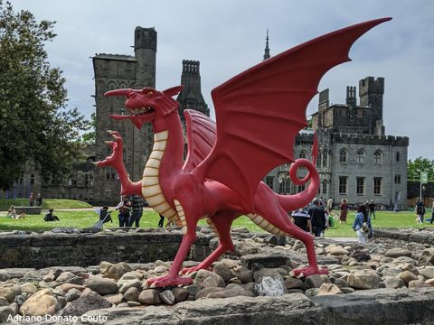 Ao fundo, prédios antigos. Em primeiro fundo, uma escultura de um dragão vermelho, um dos símbolos do País de Gales e figura presente em sua bandeira.